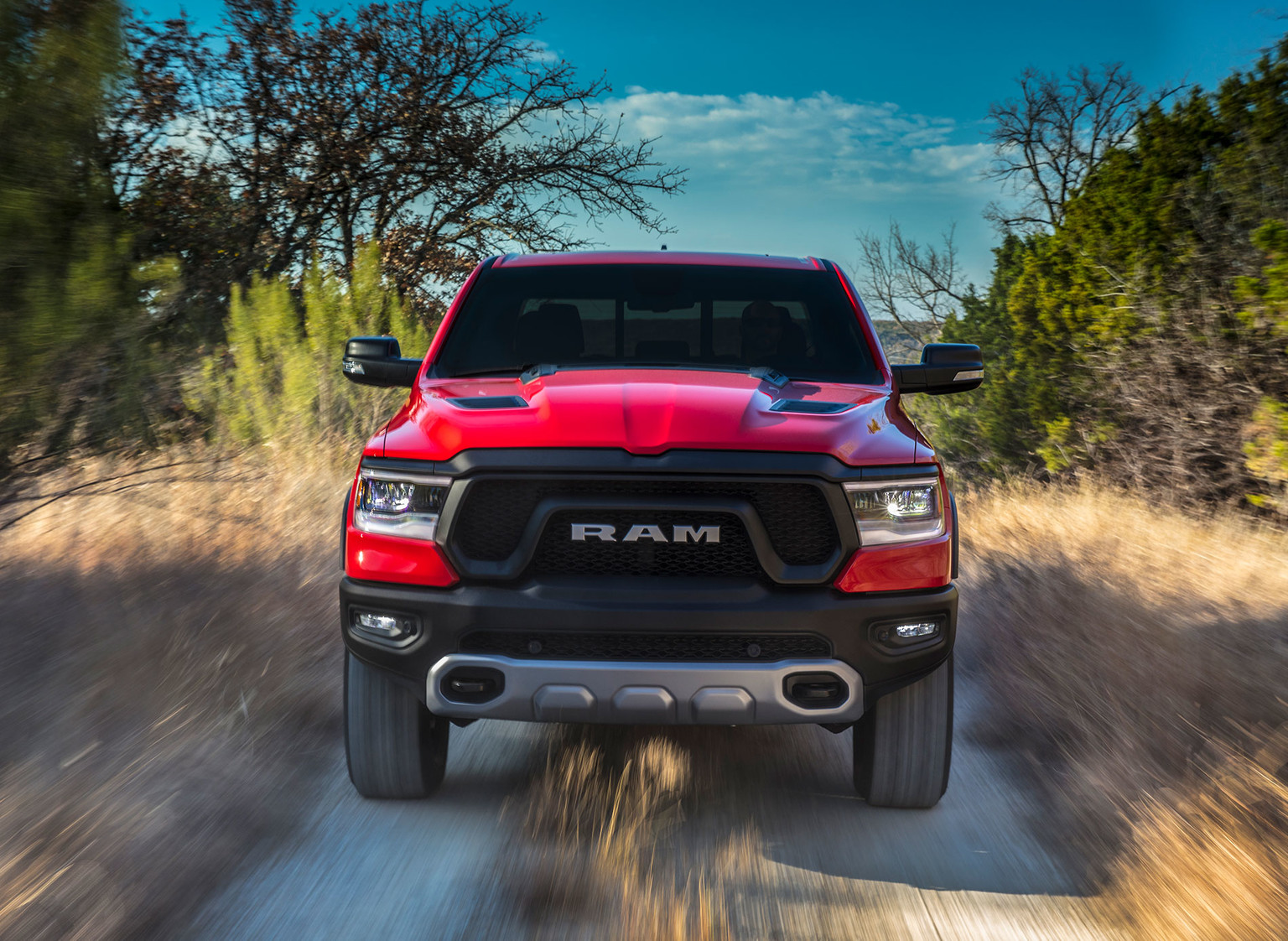 Camion Ram 1500 2019 rouge roulant à travers une plaine