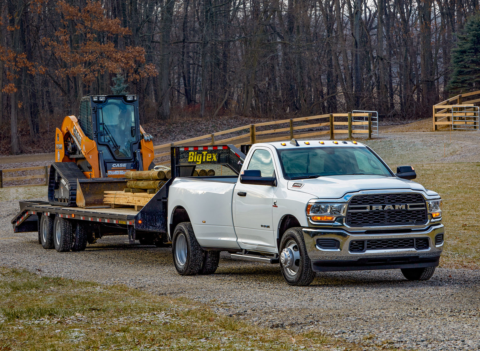 White 2019 Ram HD pickup Truck Towing a Yellow Loader