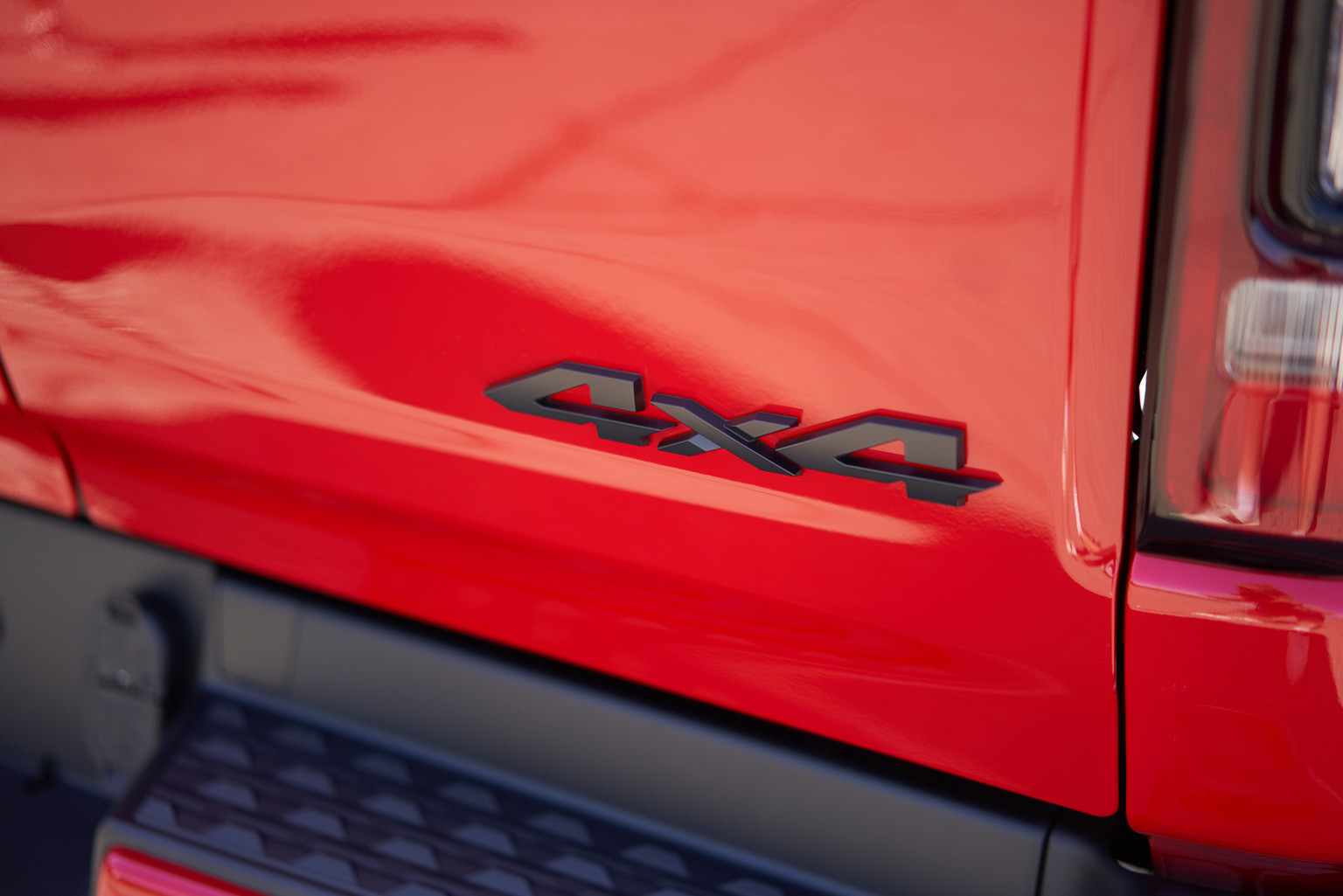 Black 4x4 badge on the tailgate of the red 2020 Ram 1500 Sport.