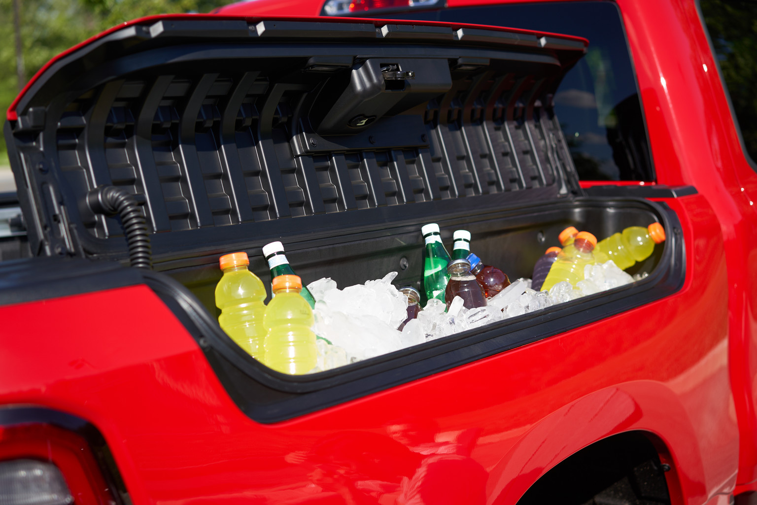 Side rail storage bin compartment of the 2021 Ram 1500 Sport filled with ice and beverages.