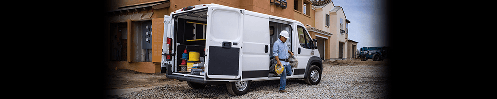Ram ProMaster garé sur un site de construction illustrant un travailleur descendant du véhicule.