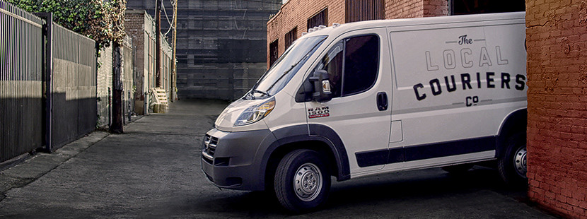 Un Ram ProMaster blanc tourne dans une rue secondaire