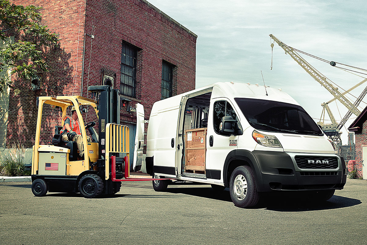 The white 2020 Ram ProMaster parked while man loading cargos using its side door