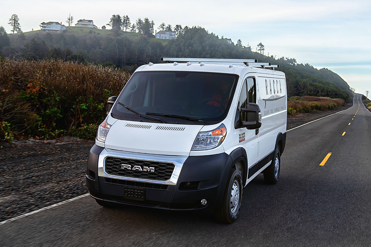 The white 2020 Ram ProMaster being driven on a road through plains