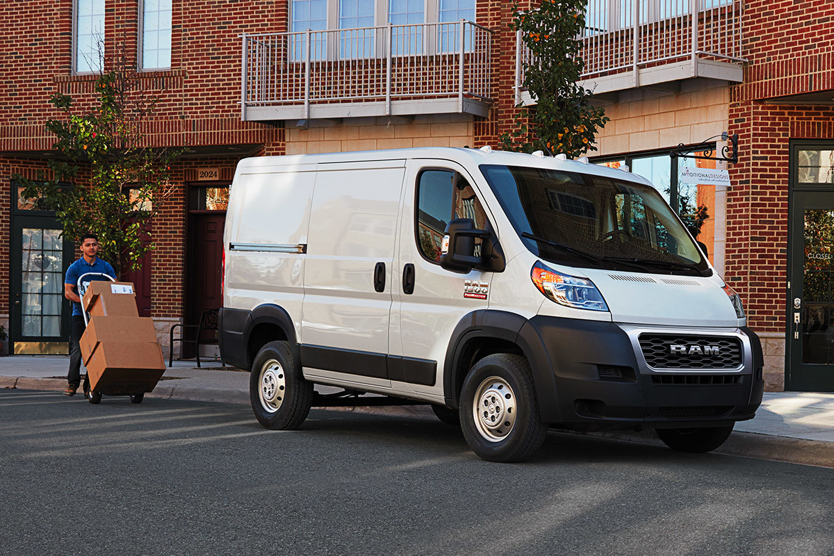 The white 2020 Ram ProMaster parked on a road in front of building