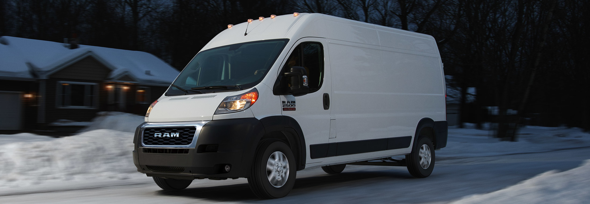 Ram ProMaster driving down a snowy residential road.