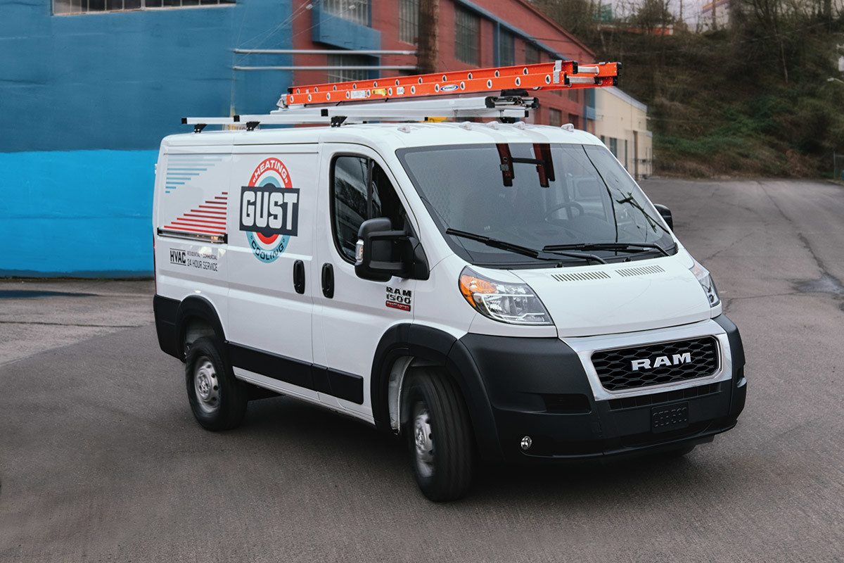 Ram ProMaster rounding a street corner in an industrial area.