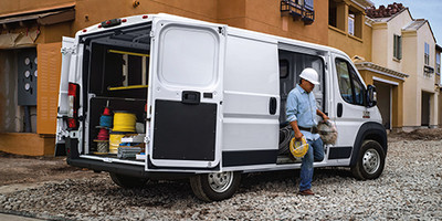 Ram ProMaster garé sur un site de construction illustrant un travailleur descendant du véhicule.