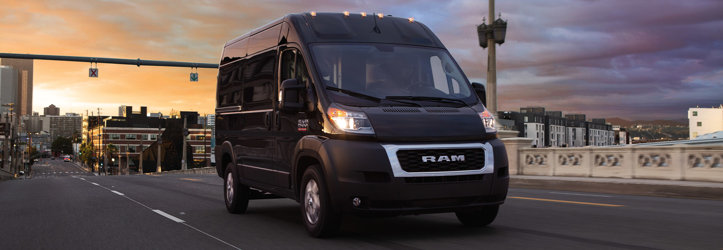 A black 2022 Ram ProMaster being driven down the road in a city