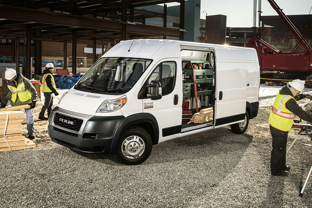 Ouvriers travaillant autour d’un Ram ProMaster 2022, illustré en blanc, garé