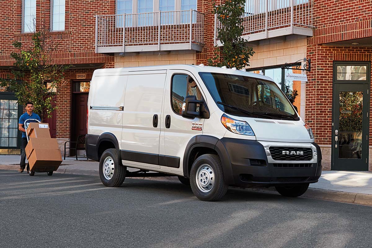 A white Ram ProMaster parked outside a building