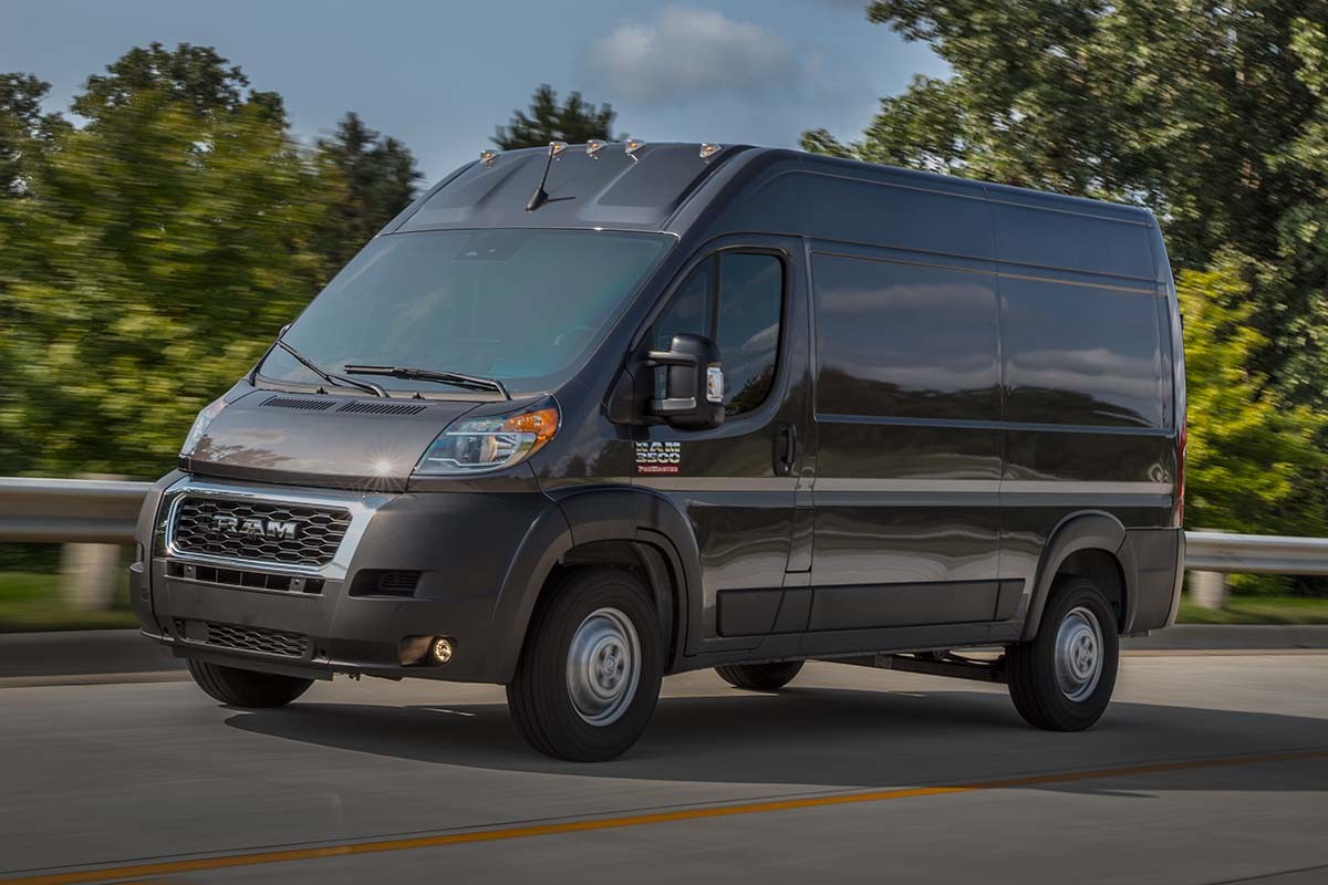 A gray Ram ProMaster driving on a bending road