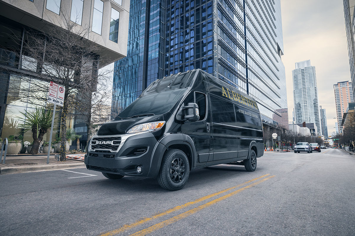 Un Ram ProMaster noir 2023 roulant sur une route en ville.