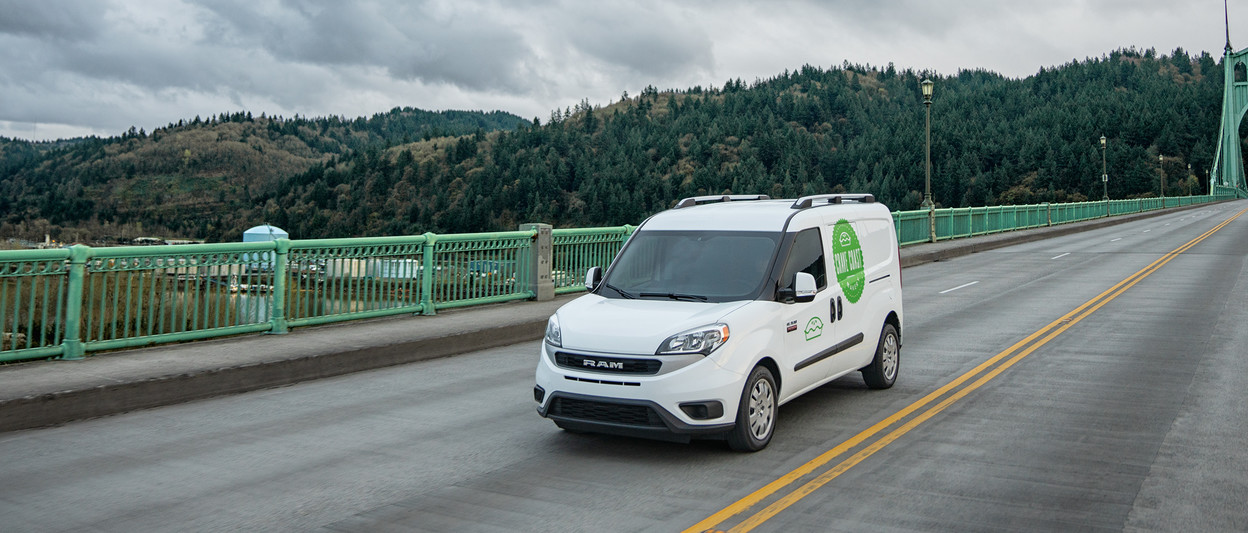 Ram ProMaster City 2019 passant sur un pont, illustré en blanc