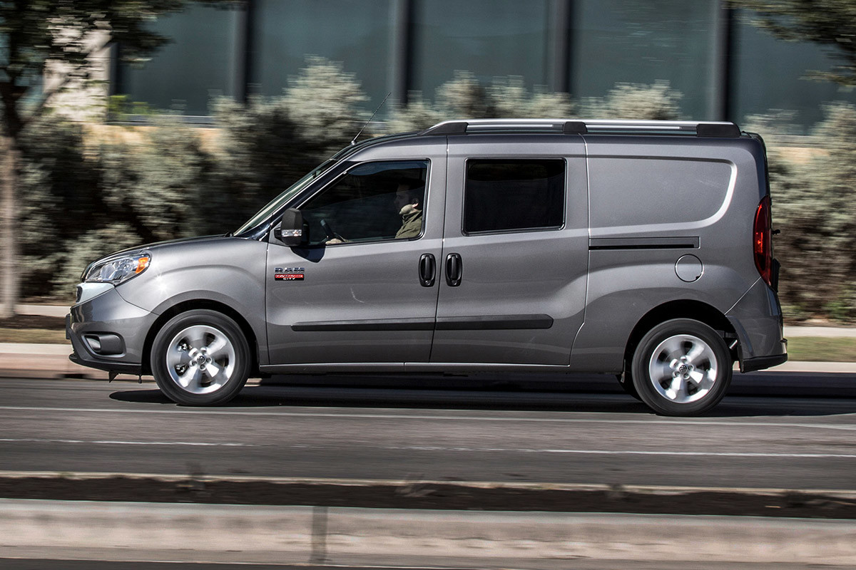 Vue latérale d'un Ram ProMaster City argenté 2022 roulant sur une route.