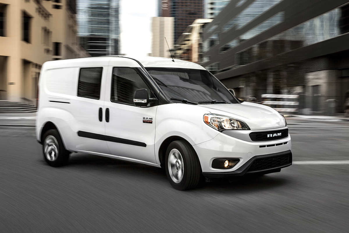 Un Ram ProMaster City 2022 blanc roulant sur une route de la ville.
