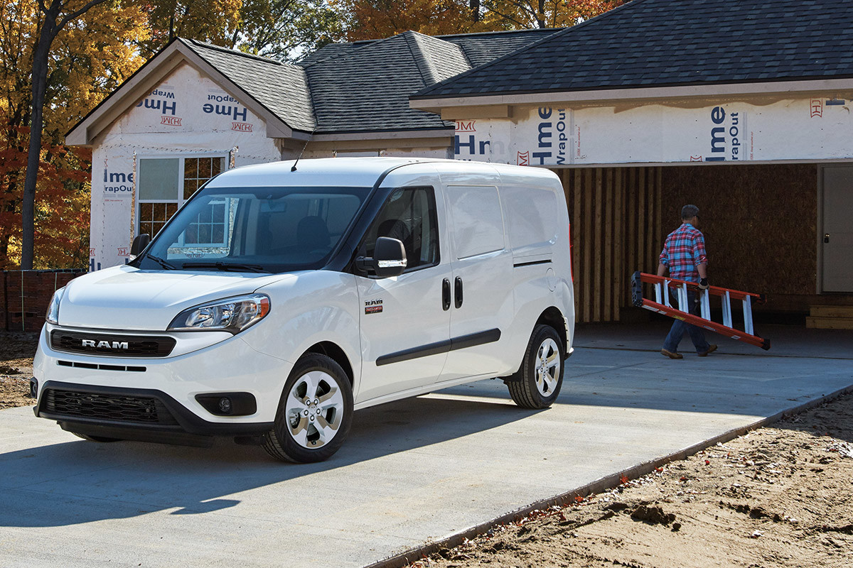 Un Ram ProMaster City 2022 blanc garé devant une maison de banlieue en construction.