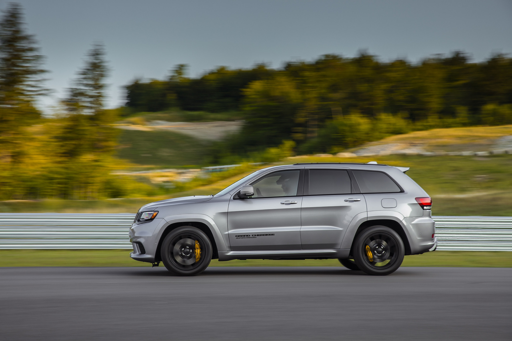  Person wearing a helmet driving a 2021 Jeep Grand Cherokee Supercharged on a racetrack