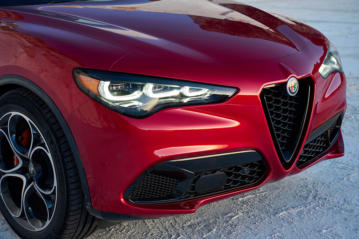 Front view of an Alfa Rosso 2025 Alfa Romeo Giulia, showcasing its distinctive grille and sleek headlights.