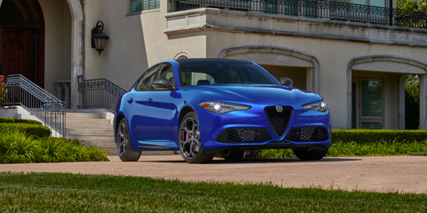 Blue 2020 Alfa Romeo Giulia parked in the front driveway of a mansion