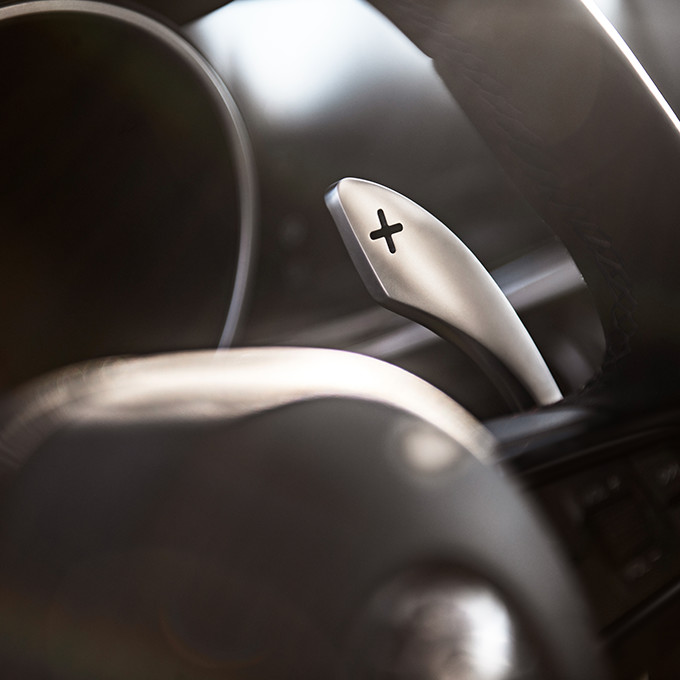 A closeup of the paddle shifter on the steering wheel of a 2023 Alfa Romeo Giulia.
