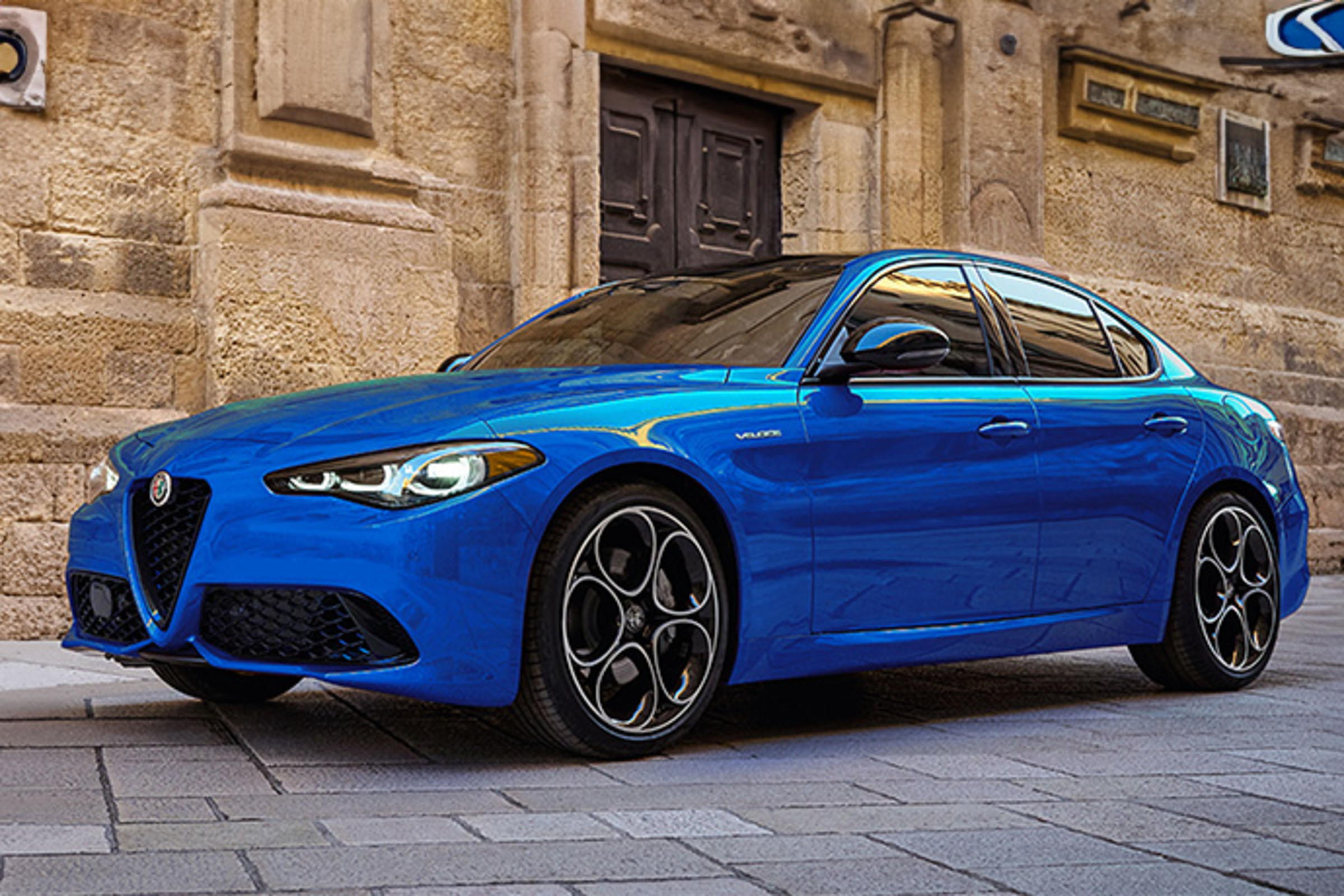 Une Alfa Romeo Giulia bleue 2025 roulant sur une route ouverte.