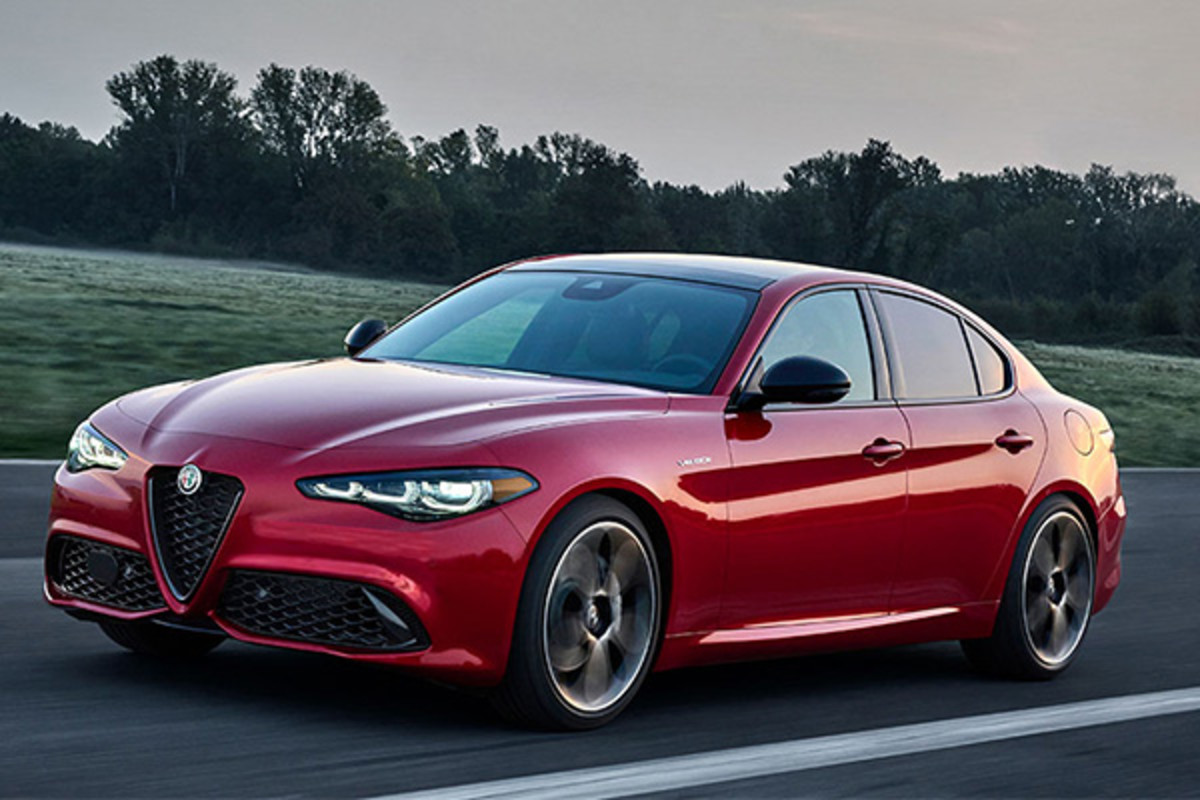 Une Alfa Romeo Giulia rouge 2025 roulant sur une route ouverte à travers.