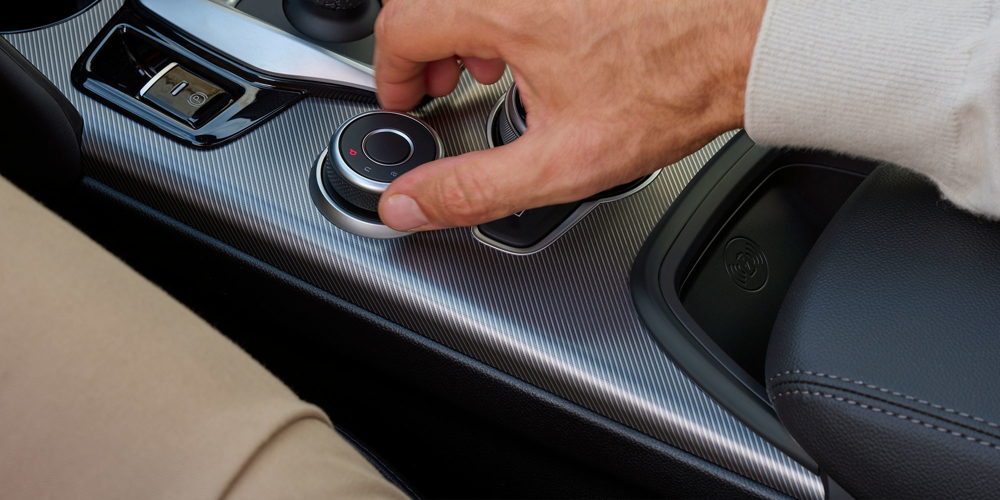 Close-up of the drive mode system (DNA) in the 2025 Alfa Romeo Giulia, with a hand turning the control knob.