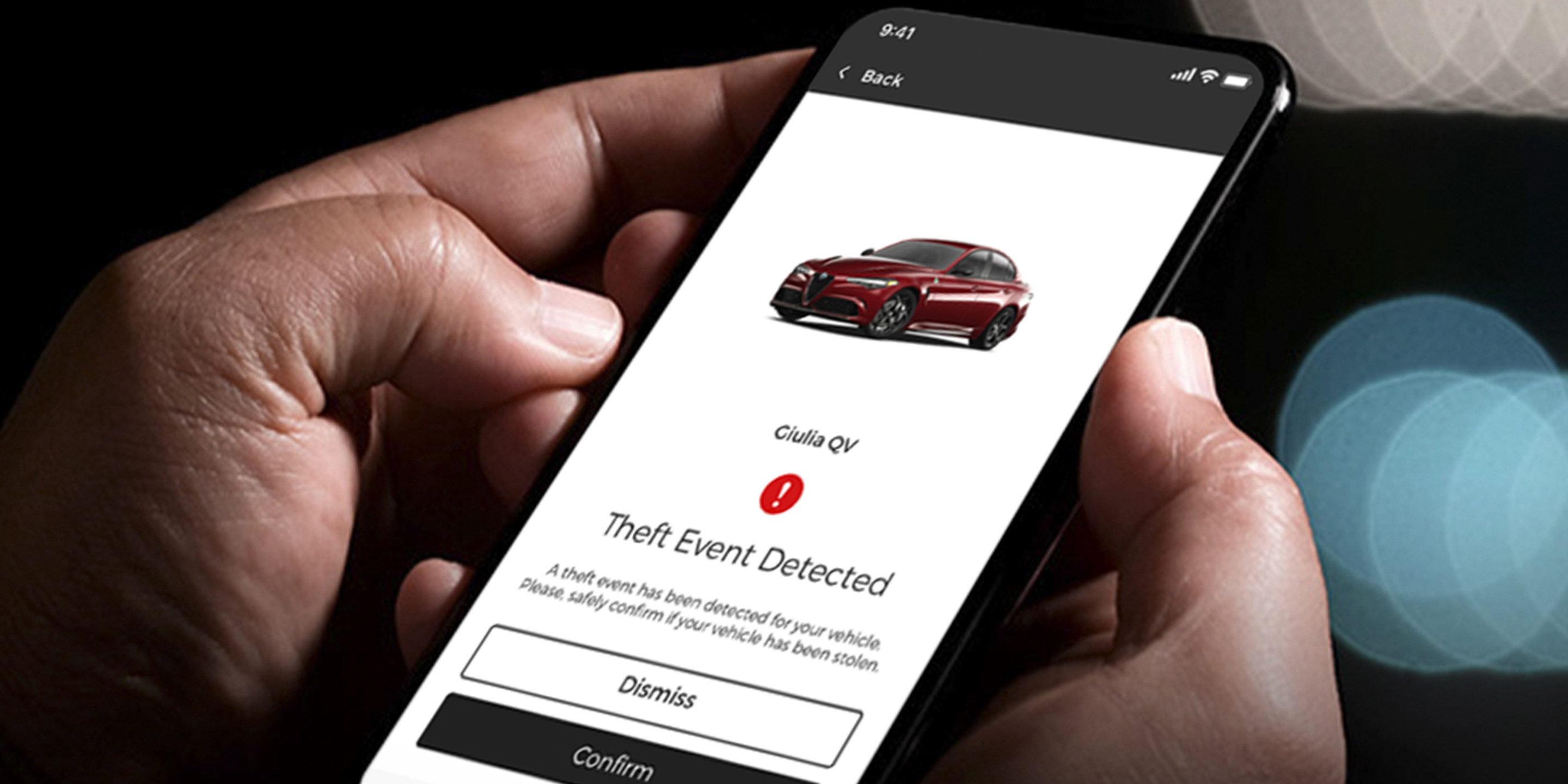 Close-up of a smartphone displaying the Alfa app, used to control the 2025 Alfa Romeo Giulia, with a notification about a detected theft event.