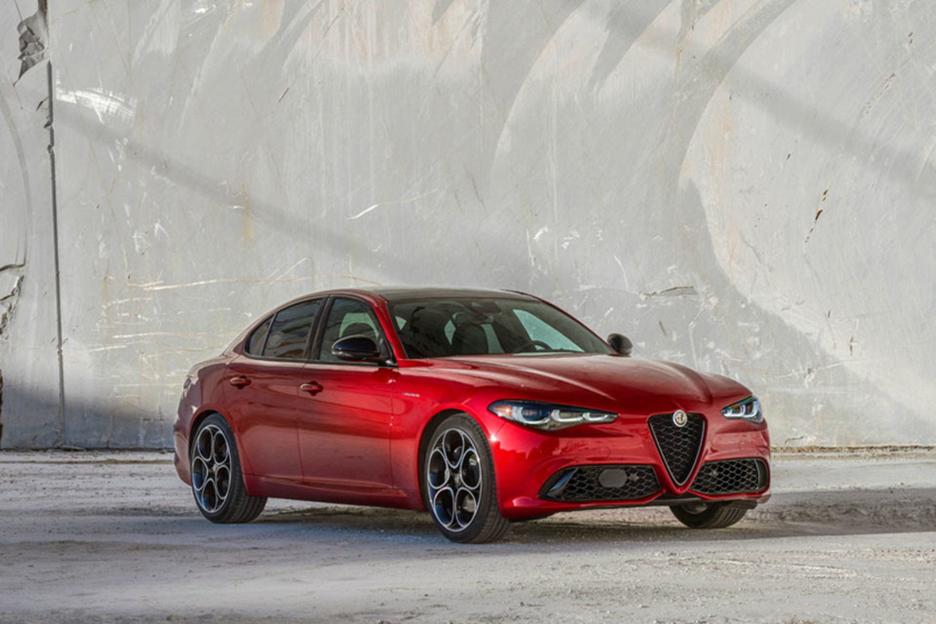 Front view of an Alfa Rosso 2025 Alfa Romeo Giulia against a marble quarry backdrop.