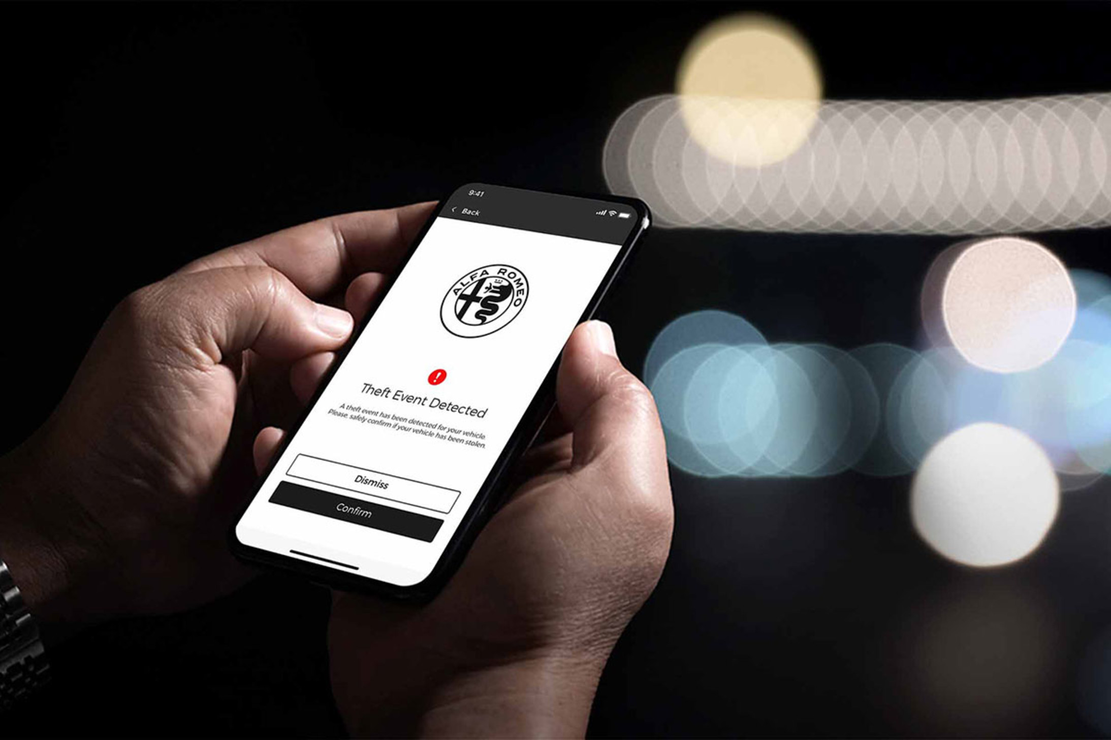 Close-up of a smartphone displaying the Alfa app, used to control the 2026 Alfa Romeo Giulia, with a notification about a detected theft event.