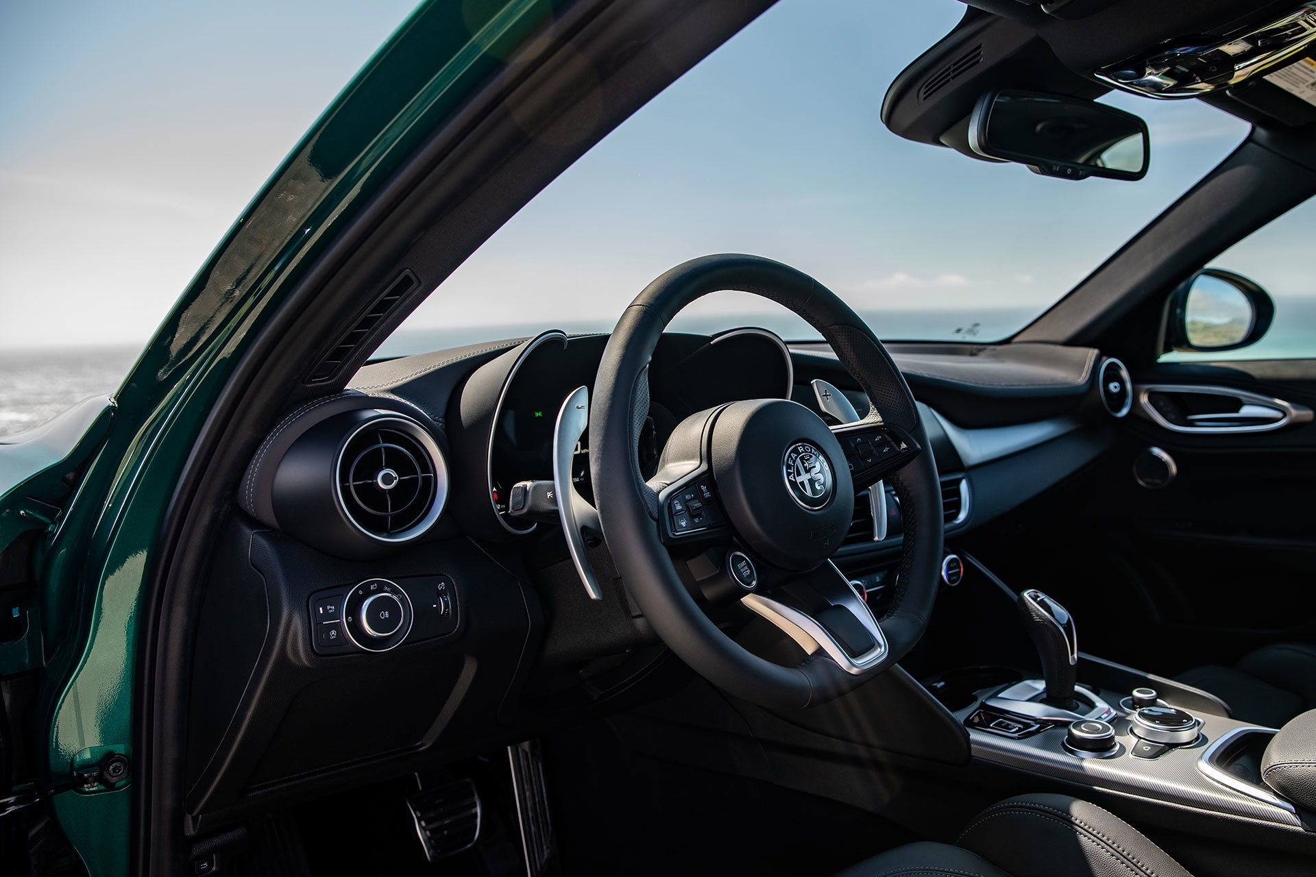 Interior view of the 2026 Alfa Romeo Giulia showcasing the steering wheel and dashboard with an ocean view.