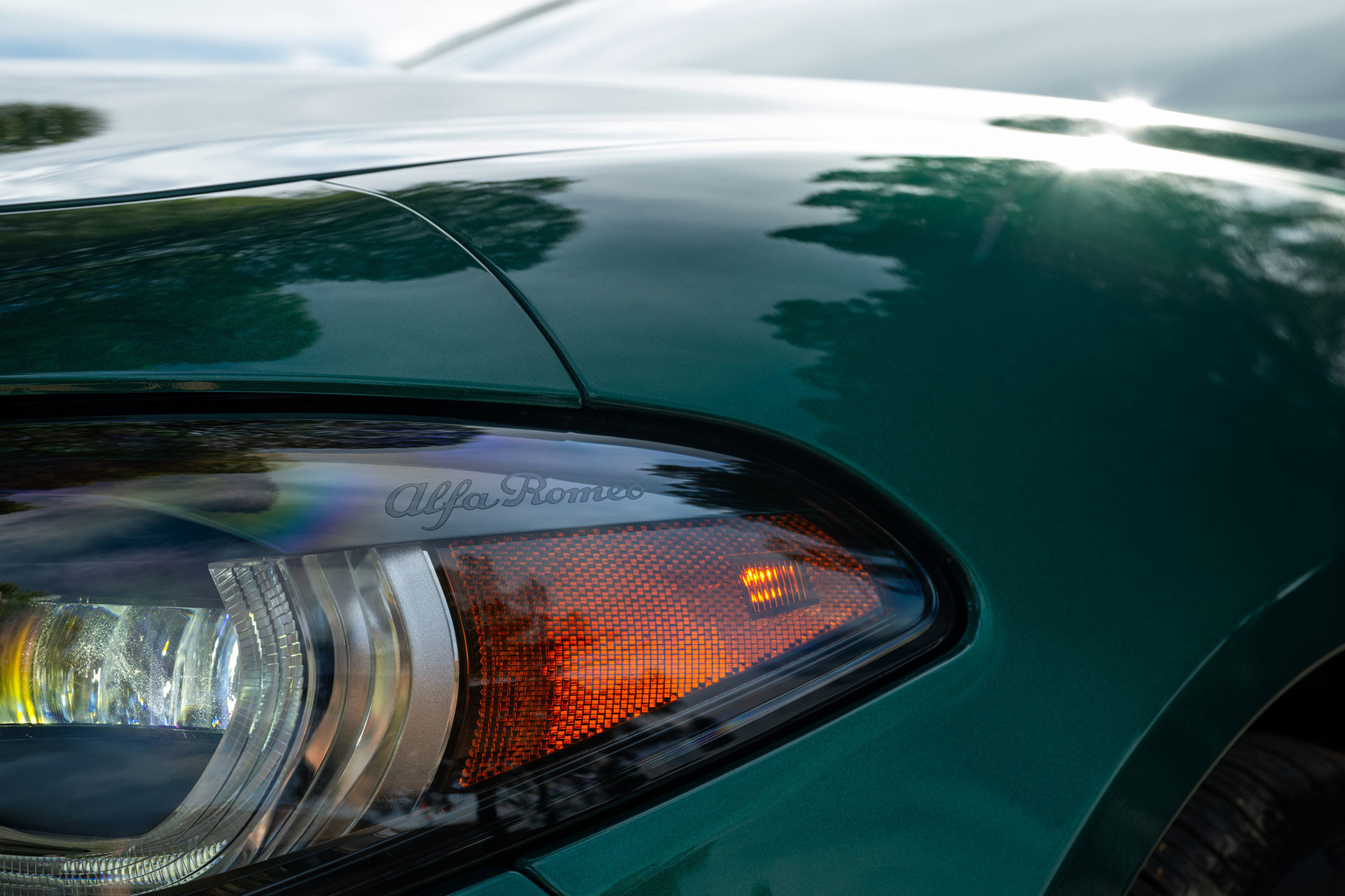 Close-up of the headlight and sleek body design of the green 2026 Alfa Romeo Giulia.