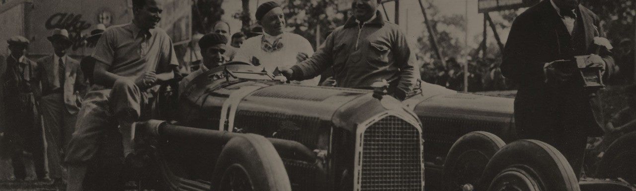 Tazio Nuvolari assis sur une Alfa Romeo P3 1932 entourée de gens