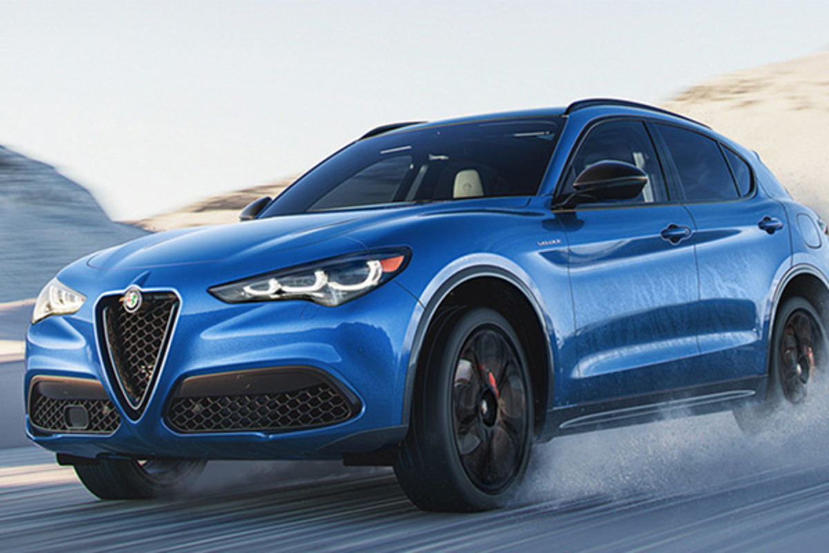 Une Alfa Romeo Stelvio bleue 2025 roulant sur un terrain enneigé, dans un paysage enneigé.