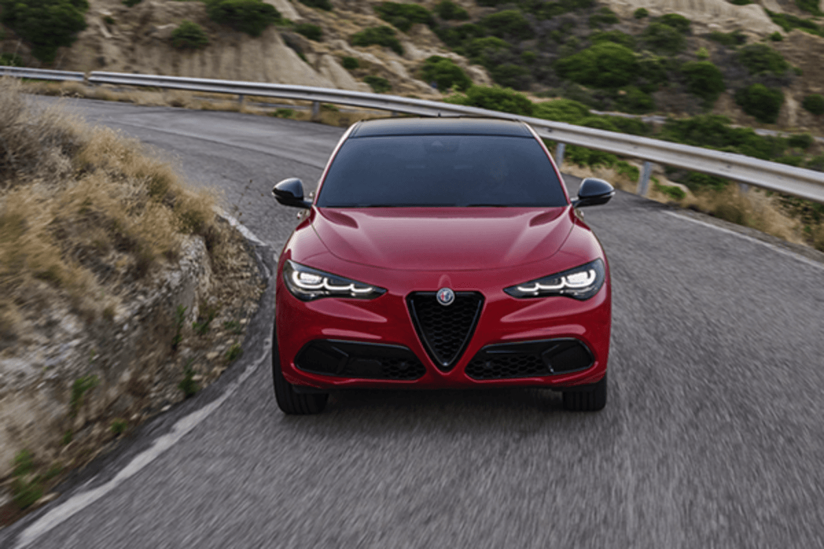 Une Alfa Romeo Stelvio rouge 2025 roulant sur une route ouverte.