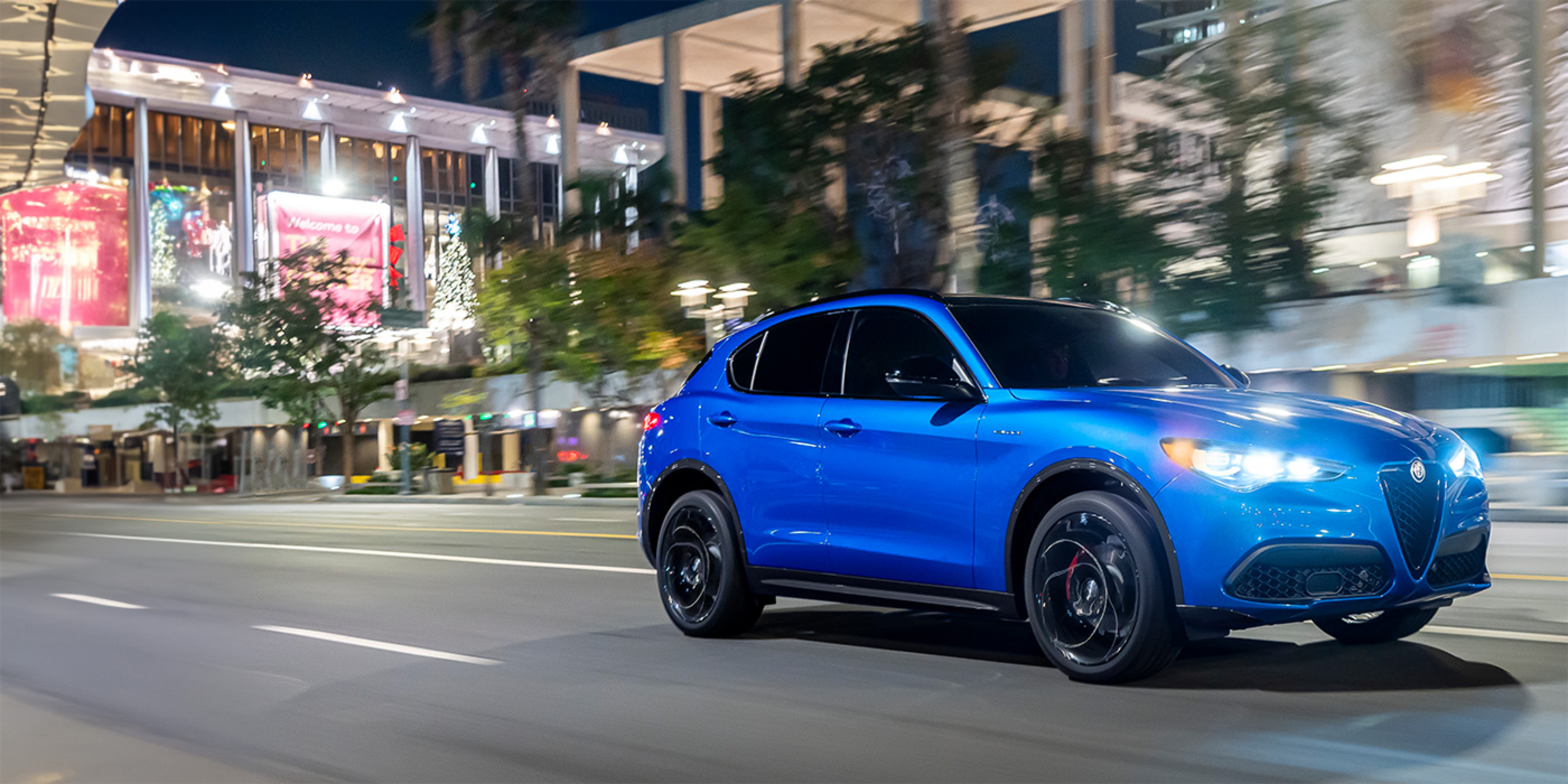 Une Alfa Romeo bleu 2025 circulant sur une route panoramique.