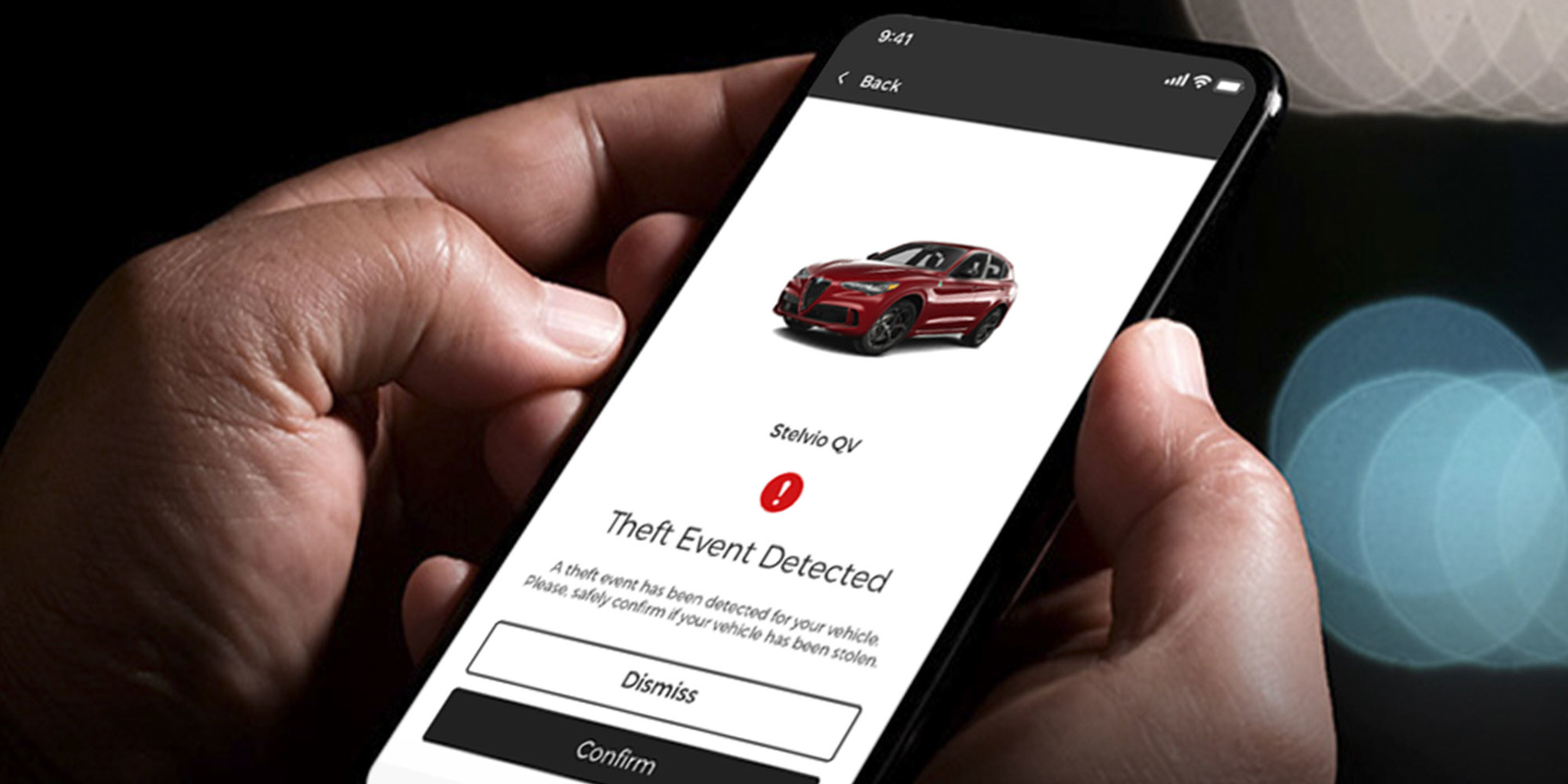 Une personne tenant son téléphone intelligent avec l'application Alfa Romeo affichée à l'écran.