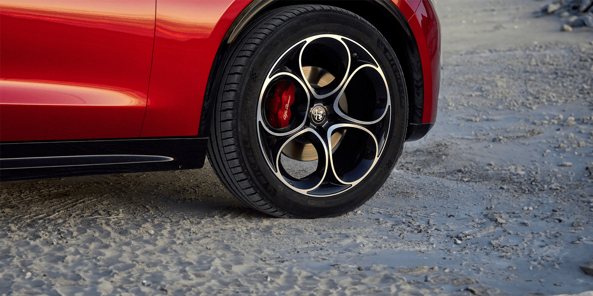 Gros plan d'une Alfa Romeo rouge 2025 mettant l'accent sur le design élégant de ses roues.