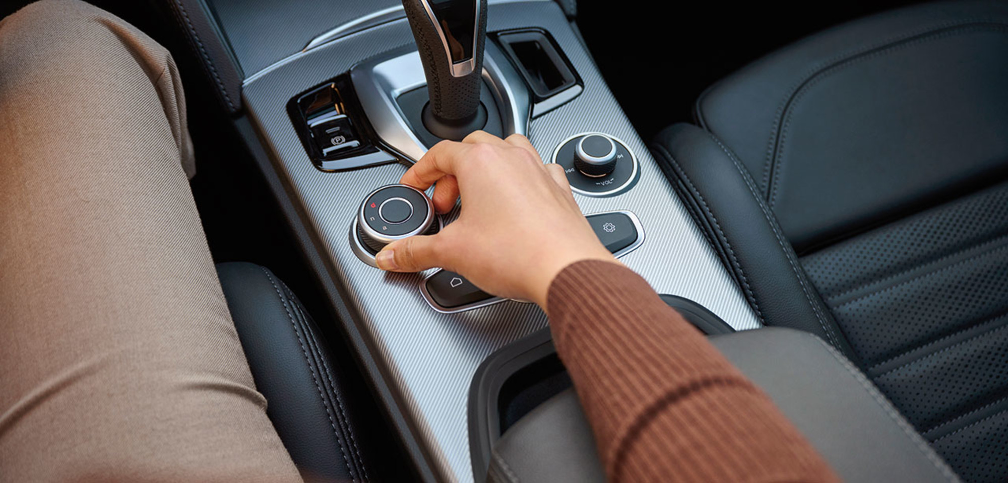 Une prise de vue intérieure du sélecteur de mode de conduite avec une femme dans le siège du conducteur sélectionnant le mode de conduite.