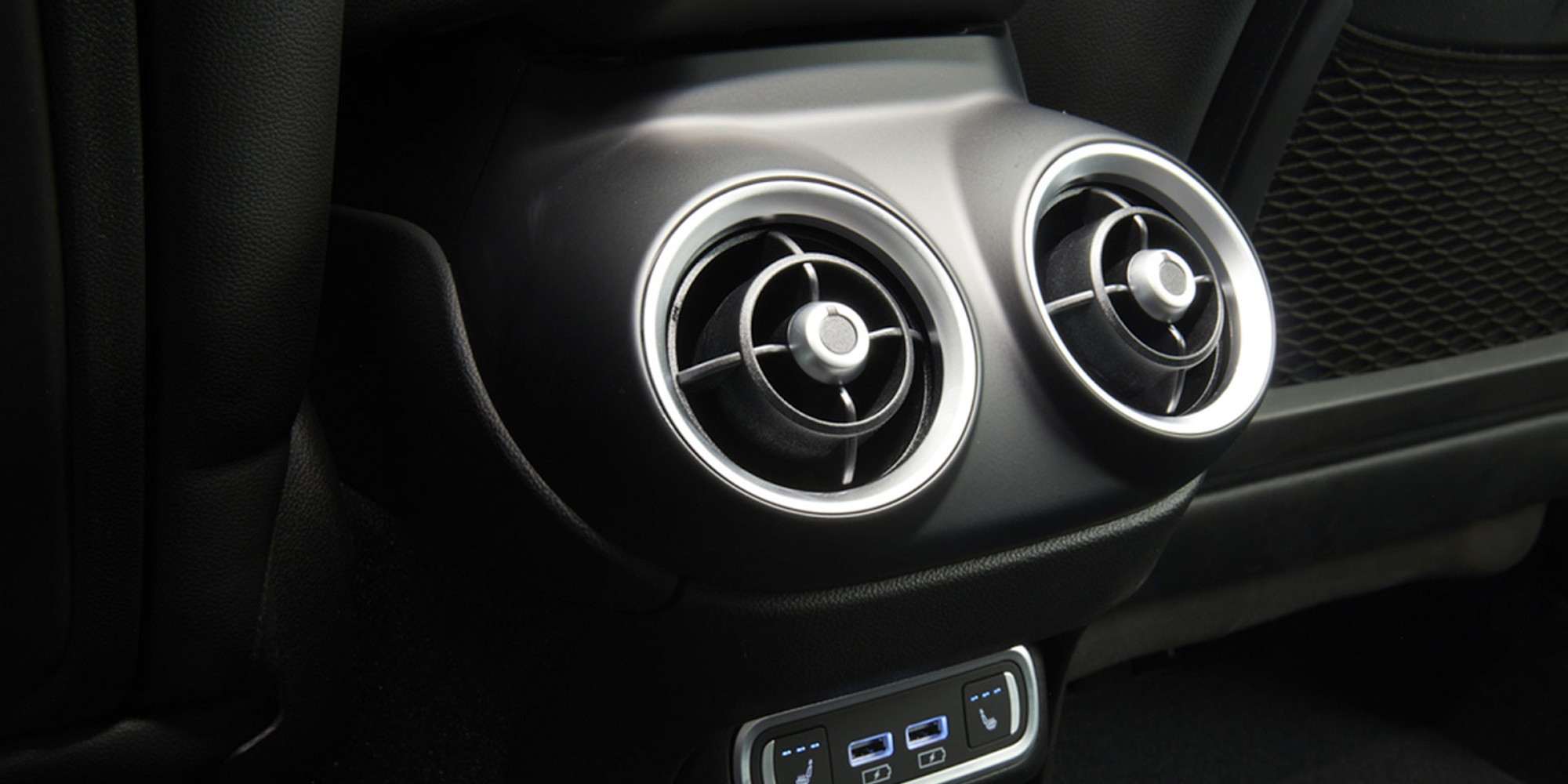 Intérieur d'un véhicule Alfa Romeo 2025 doté de bouches d'aération faisant partie du système de filtration de l'air de l'habitacle. Les bouches d'aération ont un design circulaire moderne sur fond de tableau de bord élégant.