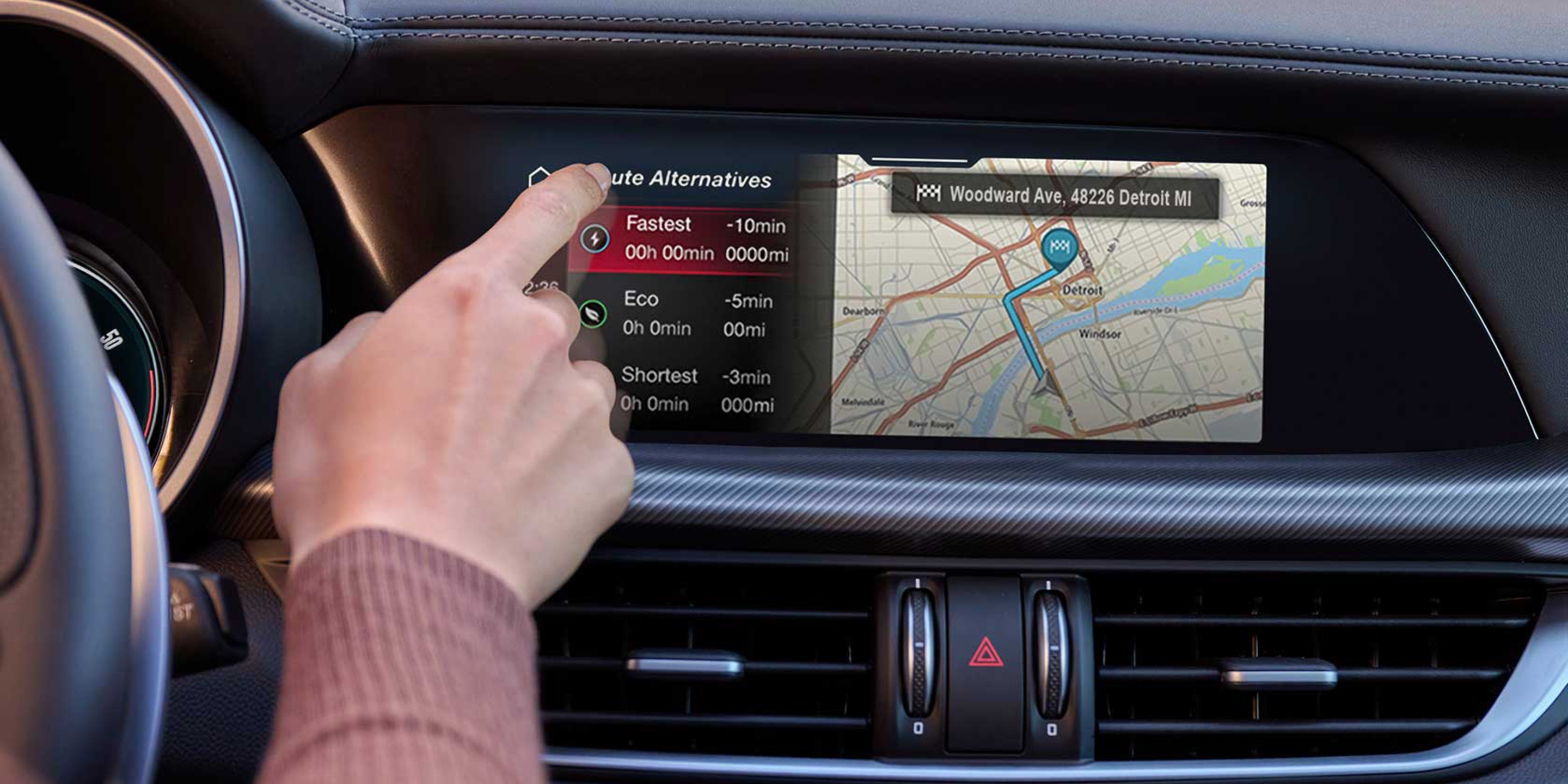 Driver interacting with the touchscreen navigation system in the 2026 Alfa Romeo Stelvio's dashboard.
