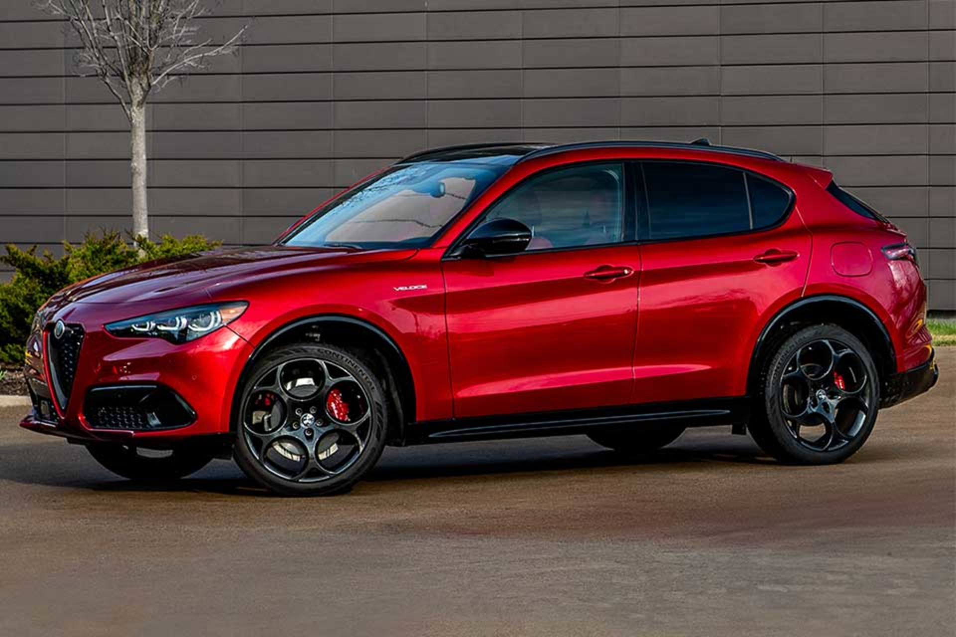 The side profile shot of a red 2026 Alfa Romeo parked outdoors, displaying its modern design.