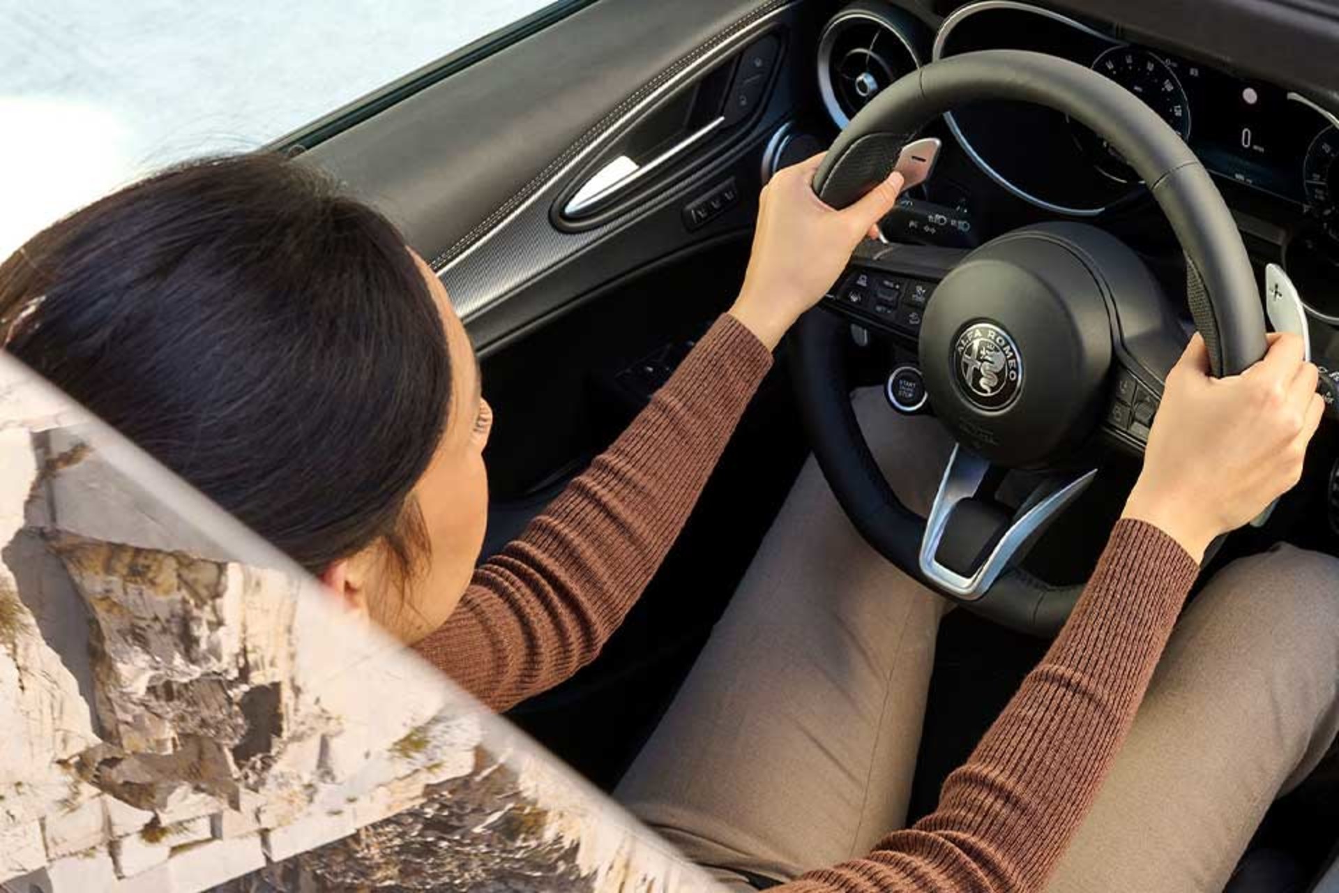 Driver's view inside the 2026 Alfa Romeo Stelvio, displaying the steering wheel, dashboard, and modern infotainment system.