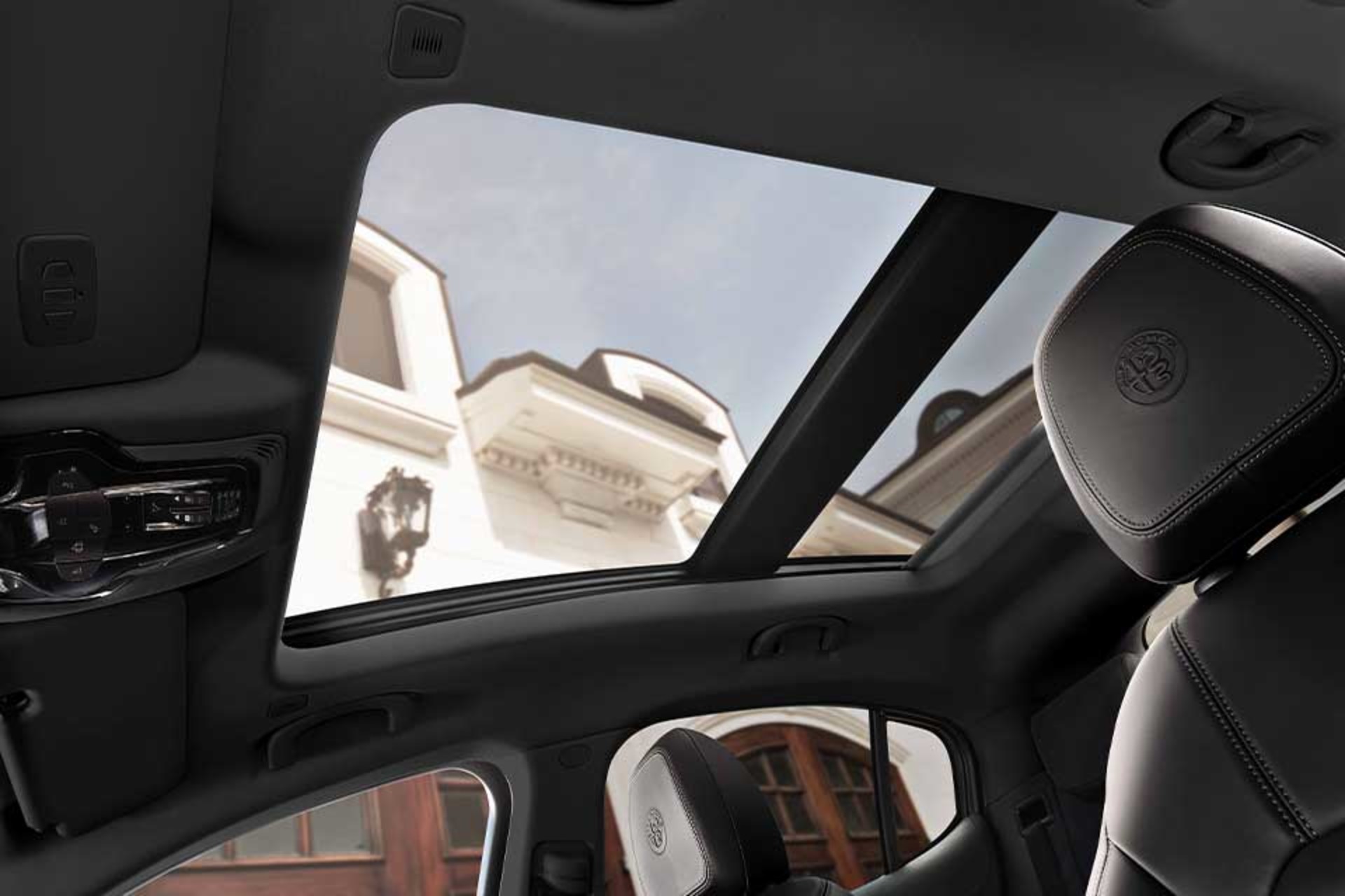 Interior view of the 2026 Alfa Romeo Stelvio showcasing the panoramic sunroof and sleek black leather seats.