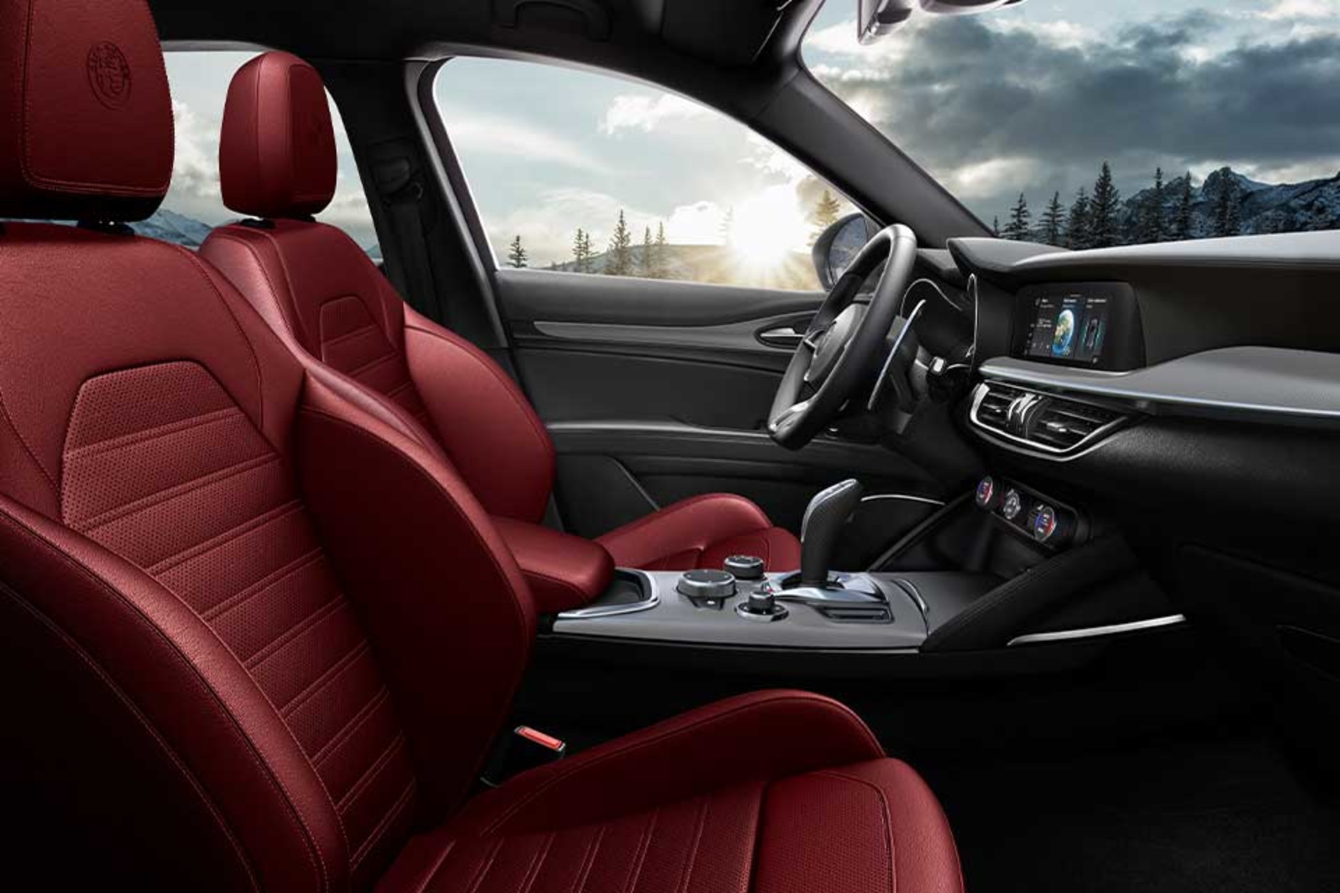Interior of the 2026 Alfa Romeo Stelvio featuring luxurious red leather seats and a sleek dashboard with a scenic view outside.