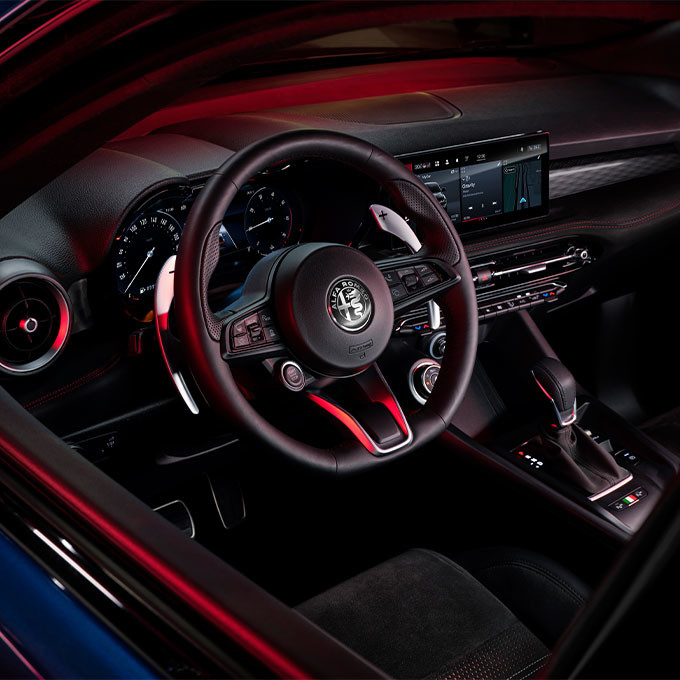 Closeup of a black steering wheel for the 2023 Alfa Romeo Tonale hybrid SUV.