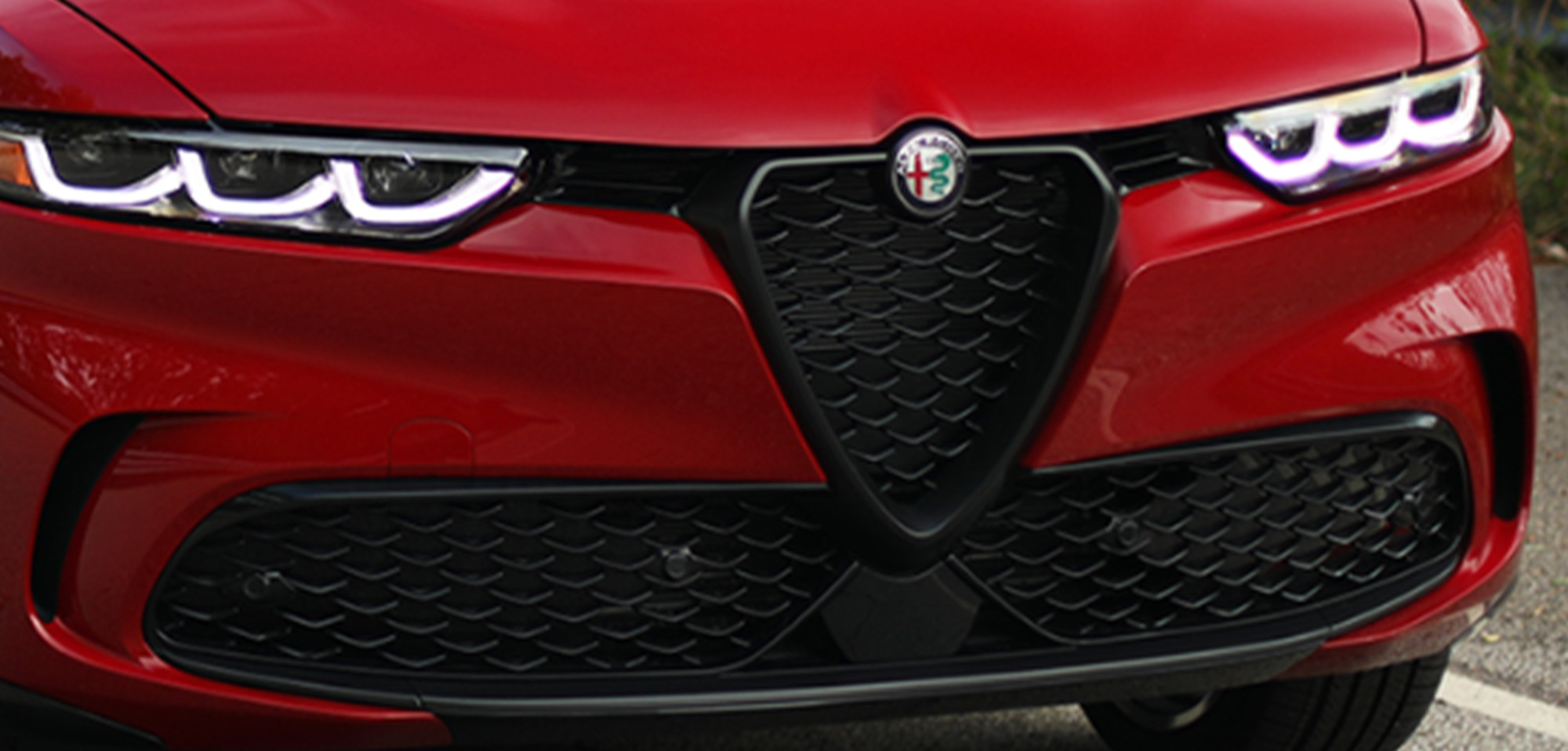 Plan rapproché de la calandre et des phares d’un Alfa Romeo Tonale 2025 de couleur Alfa Rosso.