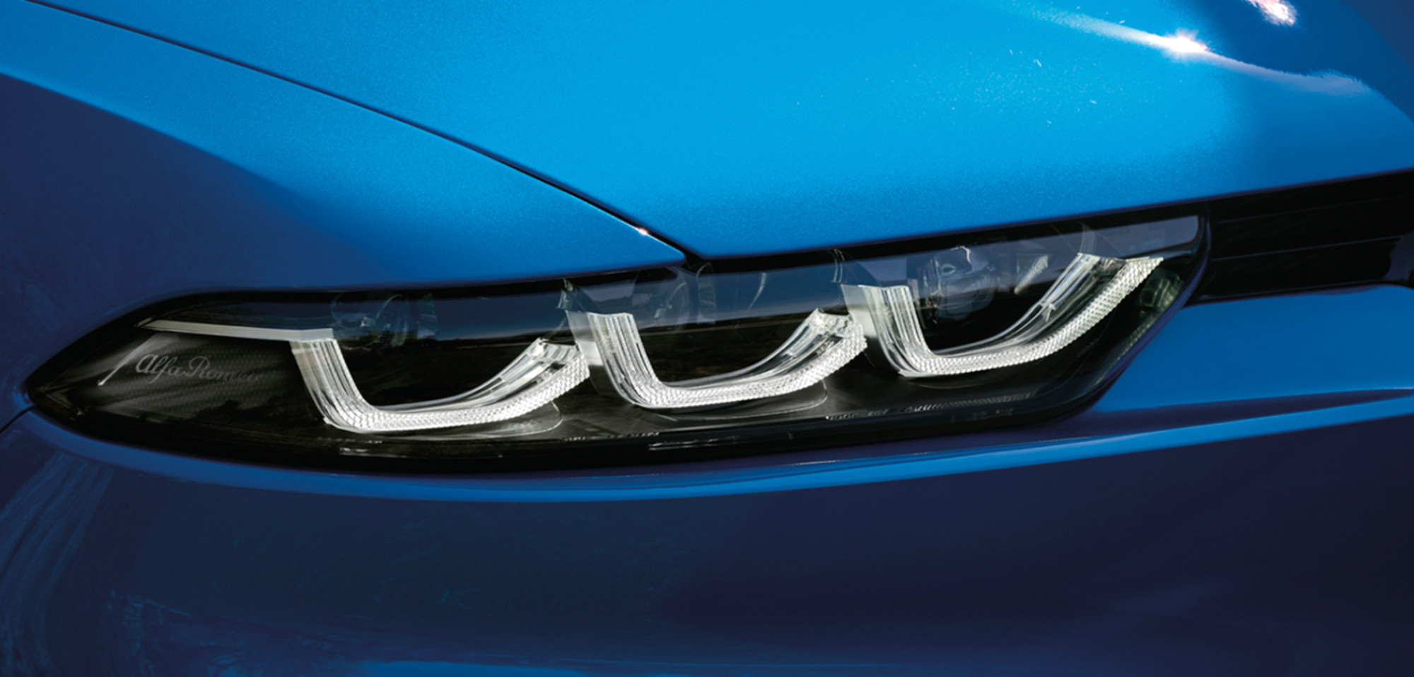 Plan rapproché du phare droit sur un Alfa Romeo Tonale 2025 de couleur bleu Misano métallisé.
