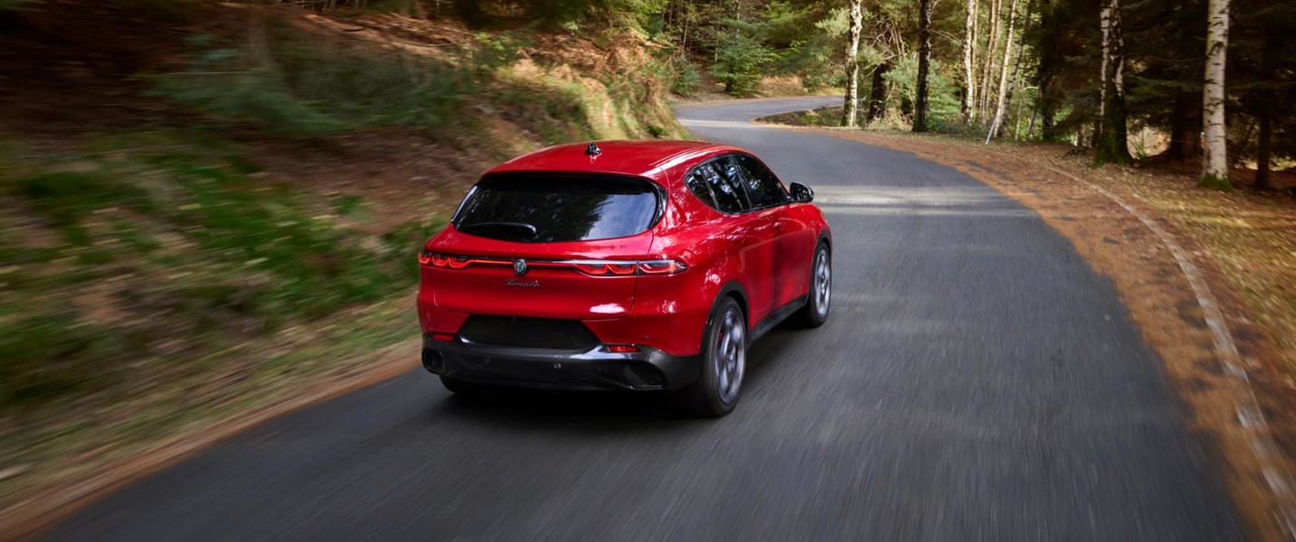 Vue arrière de l’Alfa Romeo Tonale 2025 stationné sur une route forestière.
